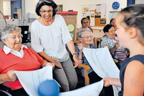 Schulkinder und Senioren spielen Ball, während Projektinitiatorin Hildegard Gans (Mitte) zuschaut.