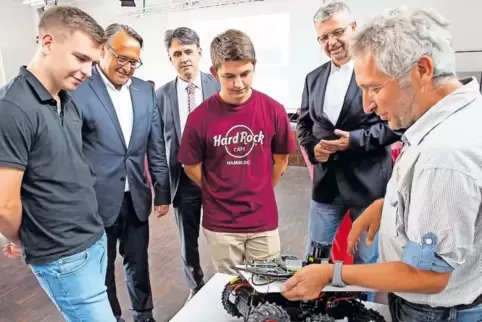 Professor Gerd Bitsch von der Hochschule Kaiserslautern erklärt bei der Firmenkontaktbörse den autonomen mobilen Roboter: von li