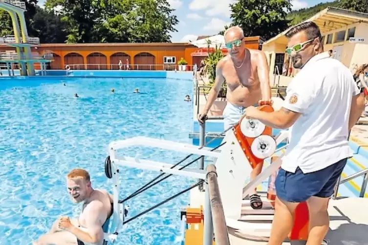 Der neue Lift in Aktion: Schwimmmeister Fabian Walter hilft Christian Werner, ins Wasser zu kommen. Im Hintergrund: Horst Meisen