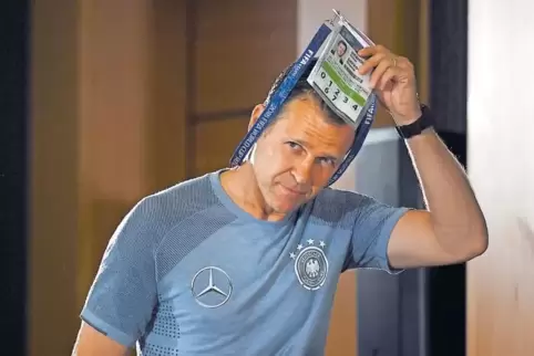 Alles ordentlich: Oliver Bierhoff legt vor der gestrigen Pressekonferenz seine WM-Akkreditierung ab.
