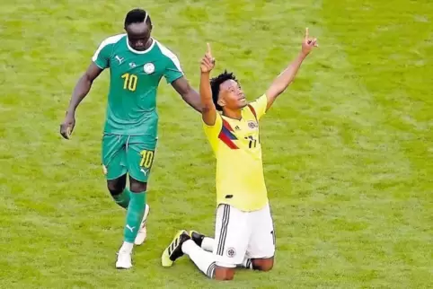 Kolumbiens Juan Cuadrado (rechts) jubelt über den Achtelfinaleinzug. Sadio Mane kann nur gratulieren.