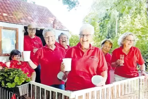 Mit Freude dabei: Im Vorgarten eines Siedlungshäuschen-Nachbaus verteilen die Seniorinnen Getränke an das Straßenpublikum.
