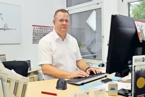 Sinischa Horvat sitzt nicht am Schreibtisch, er steht. Im Hintergrund an der Wand läuft das Karate-Küken. Vom Computer-Bildschir