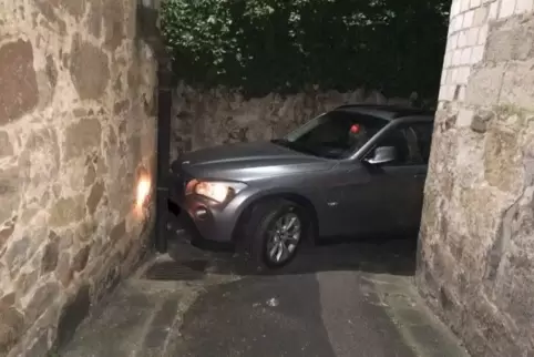 Ein Abschleppwagen musste den BMW aus der engen Gasse in der Edenkobener Innenstadt hinausmanövrieren. Foto: POLIZEI 