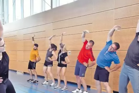 Beim gemeinsamen Training in der Sporthalle Kalmit in Maikammer: Übungsleiterin Vivien Schwaab (links) mit den Feuerwehrleuten.