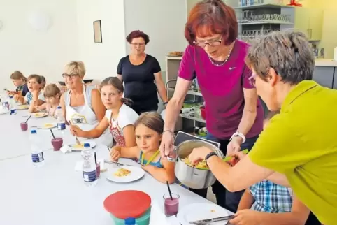 Erst kochen, dann essen: Kursleiterin Hiltrud Woll und Ingrid Stenger geben Kartoffeln mit Ricottasoße auf die Teller. Das einst