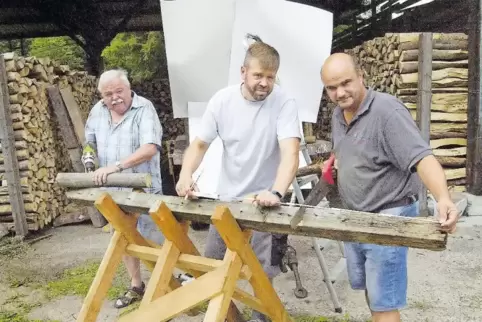 Sie bohren, sägen, und messen: Konrad Leising, Marco Leising und Stefan Herter (von links) vor dem verhüllten Motiv ihres Festwa