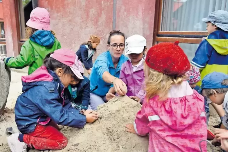 Mehr Platz braucht die Kita. Im Bild: Erzieherin Daniela Haas mit Schützlingen am Sandkasten.