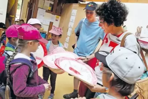 Die Kinder rüsten sich für ihren Protest mit Schildern aus, mit denen dazu aufgefordert wird, auf Produkte mit Mikroplastik zu v