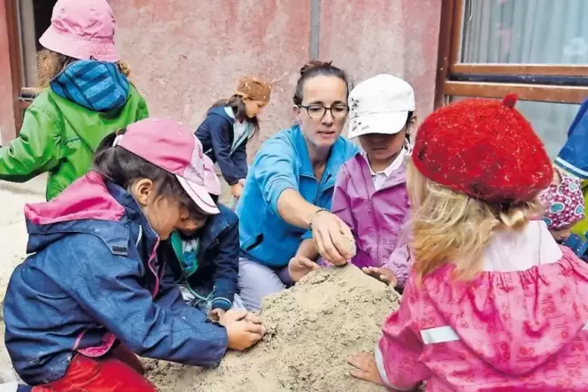 Erzieherin Daniela Haas mit »ihren« Kindern im Sandkasten. Erzieherin Daniela Haas mit »ihren« Kindern im Sandkasten.