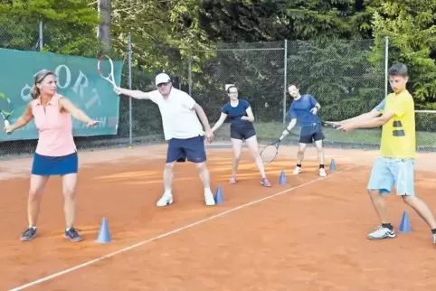Raphael Hirt (rechts) zeigt den Tennisschülern die richtige Bewegung beim Schlag.