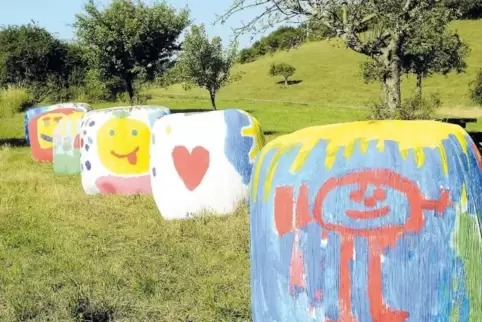 Mit farbiger Heiterkeit haben die Kinder der Bertha-von-Suttner-Schule die Silage-Ballen überzogen.