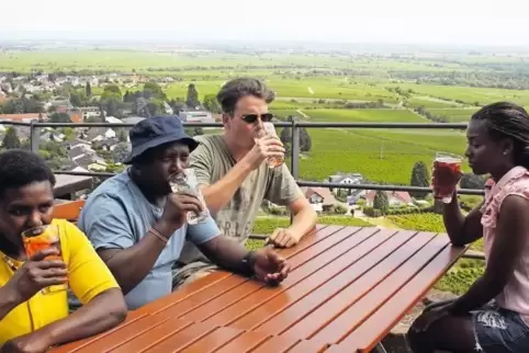 Phoebe M. Mbugua und Charles M. Nganga trinken mit Schwiegersohn Tom Wolf ihre erste Weinschorle.