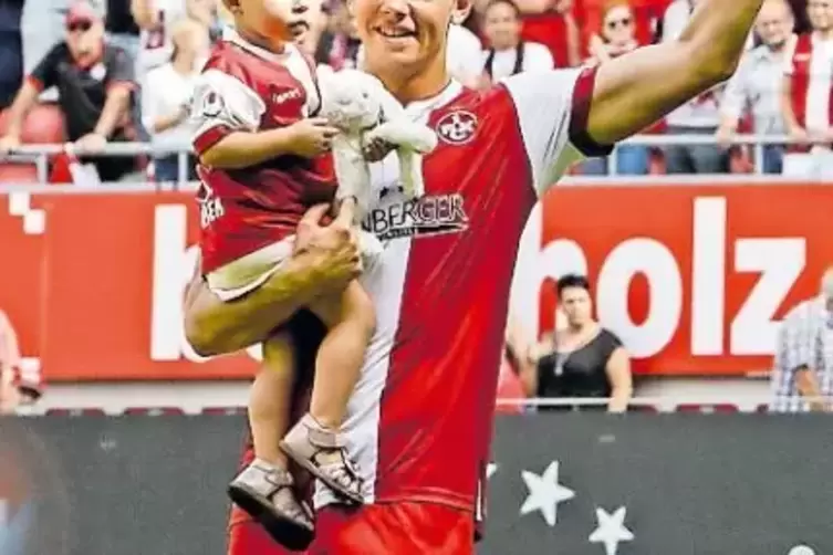 Glücklich über den 1:0-Sieg gegen die Münchner Löwen: der dänische Mittelfeldspieler des FCK, Mads Albaek, mit Töchterchen auf d