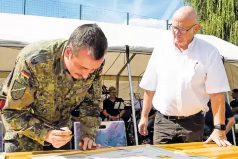 Major Sven Triebel und Ortsbürgermeister Klaus Drumm beim Unterzeichnen der Urkunde.
