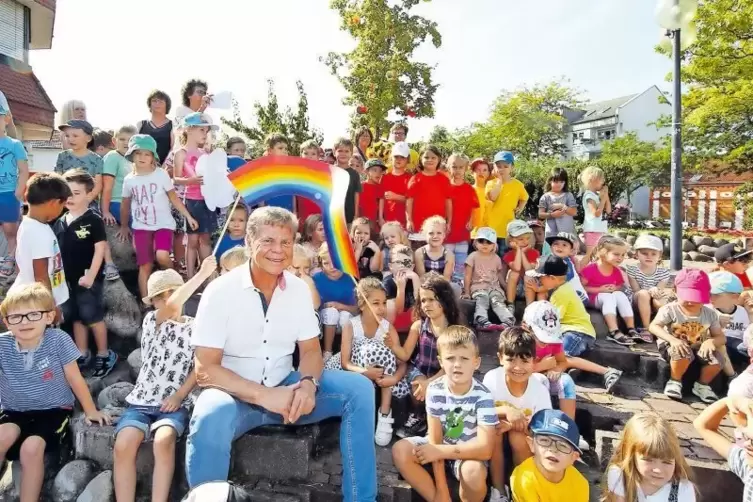 Unterm Regenbogen vor der jungen Linde: Peter Kern mit den Kita-Kindern.