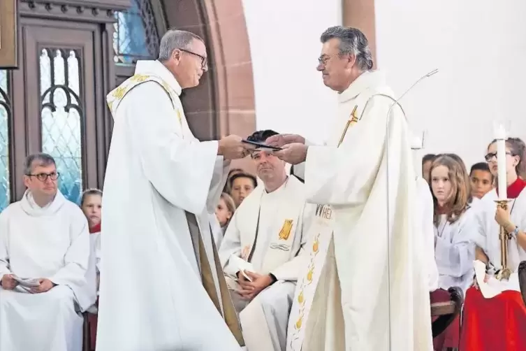 Bei einem Festgottesdienst in der Marienkirche überreichte Pfarrer Friedrich Schmit (links) Pfarrer Edmund Janson zur Verabschie