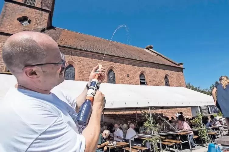 Ein gezielter Schuss und schon ist es vollbracht: Pfarrer Oliver Böß tauft die Jungstörche in ihrem Nest auf dem Kirchenschiff.