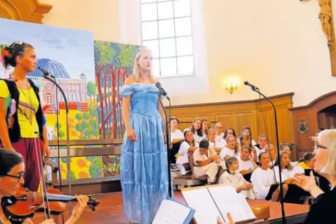 Papageno (Paula Haderlein, links) und Pamina (Anika Conrad) mit dem evangelischen Kinder- und Jugendchor Grünstadt unter Leitung