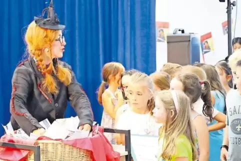 Hexe als Losfee: Nudeltraud lost die Preisträger aus. Die Kinder sind gespannt.