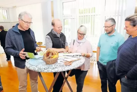 Informieren sich mithilfe von Broschüren über Energie-Einsparmöglichkeiten: Dudenhofener beim Nachbarschaftsfest im Bürgerhaus.