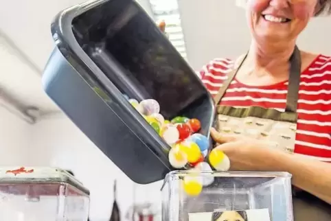 Sabine Schütz, Mitinhaberin der Firma „Kaugummimann.de“ aus dem Westerwaldkreis, befüllt zwei Automaten mit Kleinspielzeug.