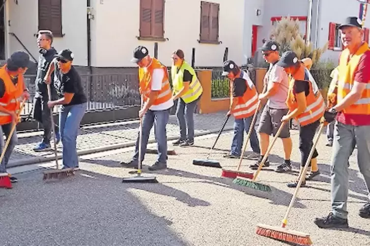 Mitglieder von &bdquo;Wir sind Kandel&ldquo; kehren nach der Demo &bdquo;braunen Dreck&ldquo; weg.