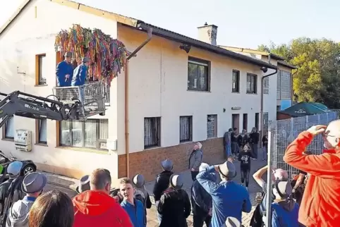 Szene vom Vorjahr: Die „Kerwenissja“ Jannik Freyler und Julian Paulus (im Baggerkorb) versuchen den Strauß am Contwiger Sporthei