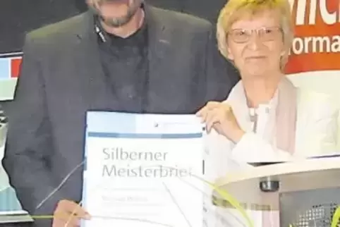 Die Präsidentin der Handwerkskammer der Pfalz, Brigitte Mannert, überreicht Michael Wafzig den Silbernen Meisterbrief.