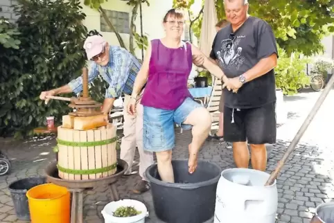 Beim Traubenstampfen: Maria Döring, unterstützt von Roland Döring und Gerhard Zickgraf.