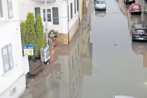 Überschwemmte Straße nach einem Starkregen in Zeiskam im Frühjahr.