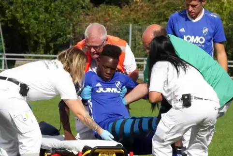 SGR-Spieler Dylan Sodji (Mitte) wurde in Fußgönheim nach erster ärztlicher Versorung und etwa einer halben Stunde Spielpause ins