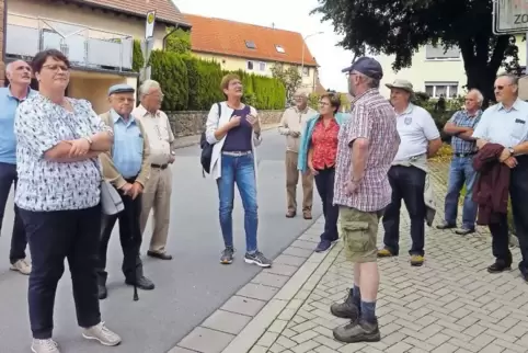 Der Dorfrundgang führte die Gruppe – in der Mitte Pfarrerin Petra Armbrust-Stepponat – auch vor der Kirche .
