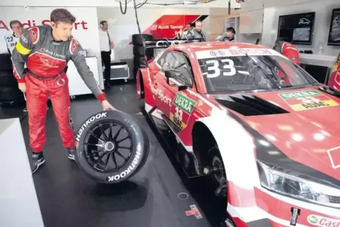 Mechaniker Armin Joerß rollt einen Reifen für das Auto von René Rast herbei: Ein kalter Reifen muss neuerdings einen Druck von 1