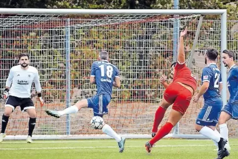 Winnweilers Sebastian Bleckmann (in Rot) zieht ab. In der Mitte Spielertrainer Andreas Gaebler vom SV Rodenbach.