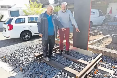 Ein Stückchen Schiene ist bereits verlegt, dann kommt noch eine Achse eines Eisenbahnwaggons drauf: Peter Stemler (links) und Pa