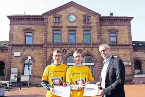 Markus und Manuel Rumschinski übergeben Ulrich Demmer, dem Leiter des DB-Bahnhofsmanagments in Kaiserslautern, (von links) ihre 
