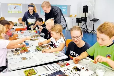 In Harthausen: Basteln mit den Betreuern Melanie Michalczak, Lorenz Worf und Rebecca Fiebig (von links).