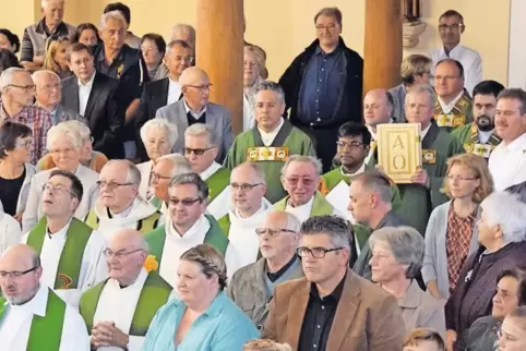 Beim Einzug in die voll besetzte Kirche: Das Evangeliar trägt Diakon Wolfgang Rhein aus Lauterecken, links hinter ihm ist Pfarre