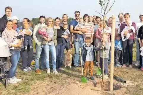 Stehen um einen Apfelbaum: die Eltern mit ihren Kindern und Ortsbürgermeisterin Friederike Ebli (links).