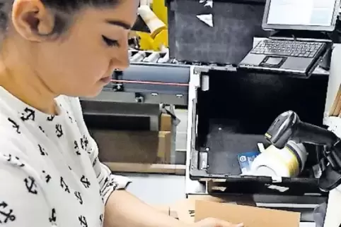 Verpackt Waren: Raihana Rahini. Eine Maschine klebt dann automatisch Adressen auf die Kartons.