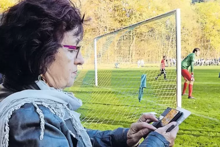 Immer live: Ursula Kästel tippt Informationen zum Geinsheimer Spiel in eine App, die sie auf ihr Mobiltelefon geladen hat.