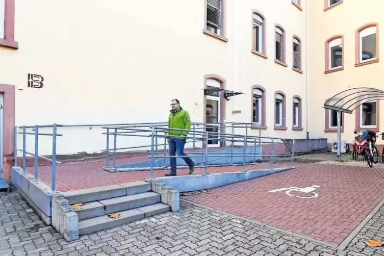 Selbsttest am Finanzamt: Geschäftsstellenleiter Florian Weilacher auf dem barrierefreien Zugang direkt neben einem Behindertenpa