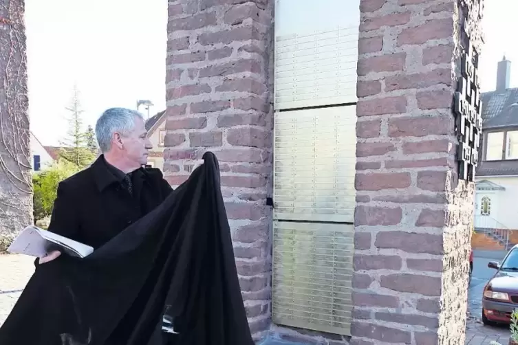 Ortsvorsteher Michael Schreiner enthüllt die neue Gedenktafel für die Opfer des Zweiten Weltkrieges in Godramstein.