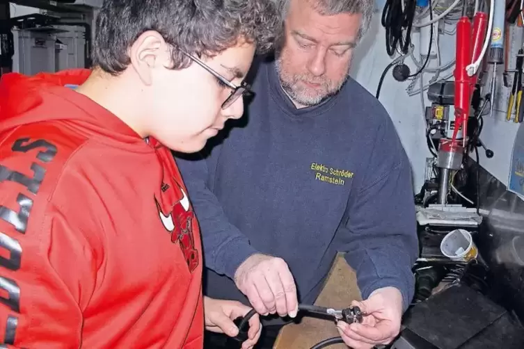 Packt mit an: Andreas Schr&ouml;der zeigt Joshua, wie ein Stecker auf ein Kabel montiert wird. Der Realsch&uuml;ler interessiert sich sehr