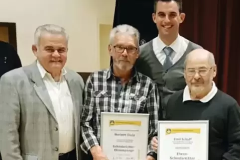Fußball-Kreisvorsitzender Udo Schöneberger (links) und Kreis-Schiedsrichterobmann Florian Benedum (hinten) zeichnen Norbert Diet