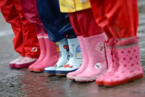 Wer mit Gummistiefeln durch den Regen läuft, behält trockene Füße.  Symbolfoto: dpa