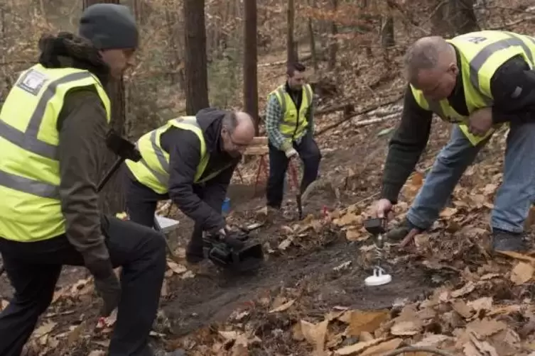 Rob Olver (mit Kamera) filmt die Suche nach Metallteilen im Leistadter Wald.  Foto: Schmidt 