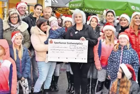 Bei der Spendenübergabe: in der Mitte (in schwarz) Marktleiterin Ramona Hingst, links daneben Marie-Sophie Eberle auf dem Arm ih