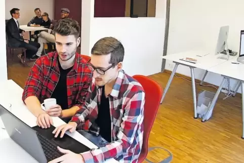 Mitarbeiter aus verschiedenen Branchen arbeiten an Co-Working-Plätzen unabhängig voneinander, können sich aber treffen und austa